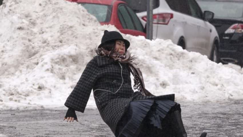 A woman falls while slipping on ice during freezing rain on Roosevelt Island, a borough of Manhattan, in New York January 5, 2014. New York City was hit on Friday by the first severe winter storm of 2014 and was still in the grip of sub-freezing weather on Sunday morning. The woman got up and walked away from the fall. REUTERS/Zoran Milich (UNITED STATES - Tags: SOCIETY ENVIRONMENT TPX IMAGES OF THE DAY)