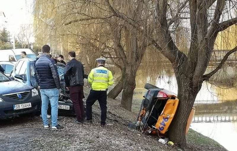 foto taxi cu roțile în sus pe malul cibinului - stă să cadă în râu