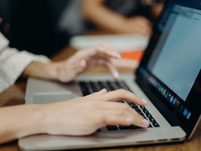 person using silver macbook pro