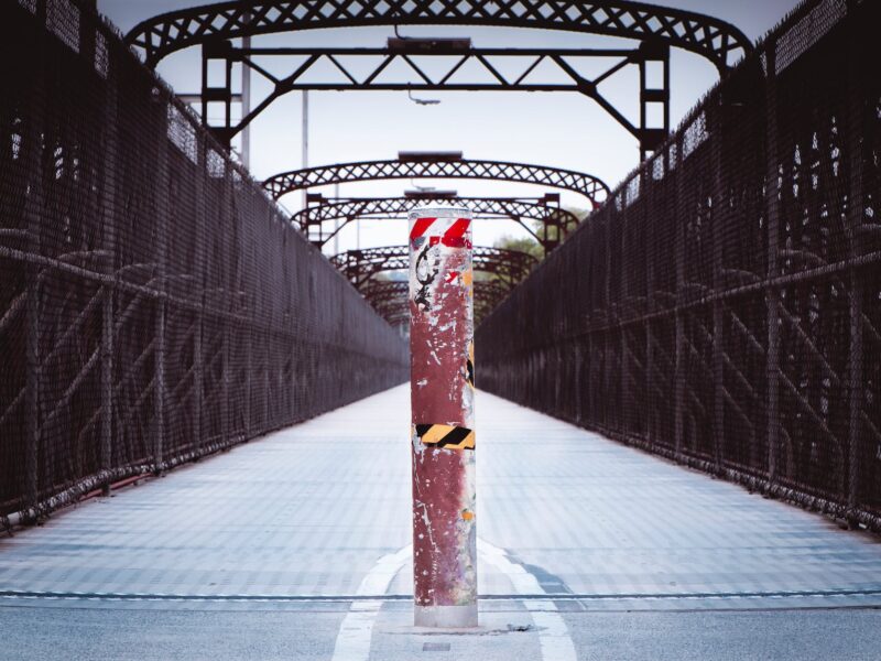 shabby dividing post in middle of pedestrian bridge