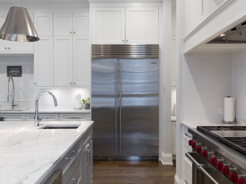 stainless steel refrigerator beside white kitchen cabinet