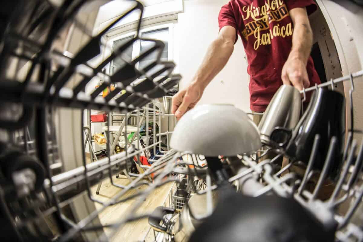 fish eye photography of man pulling the dishwasher rack