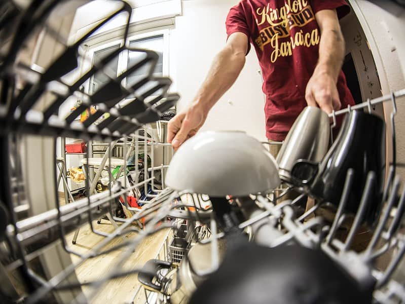 fish eye photography of man pulling the dishwasher rack