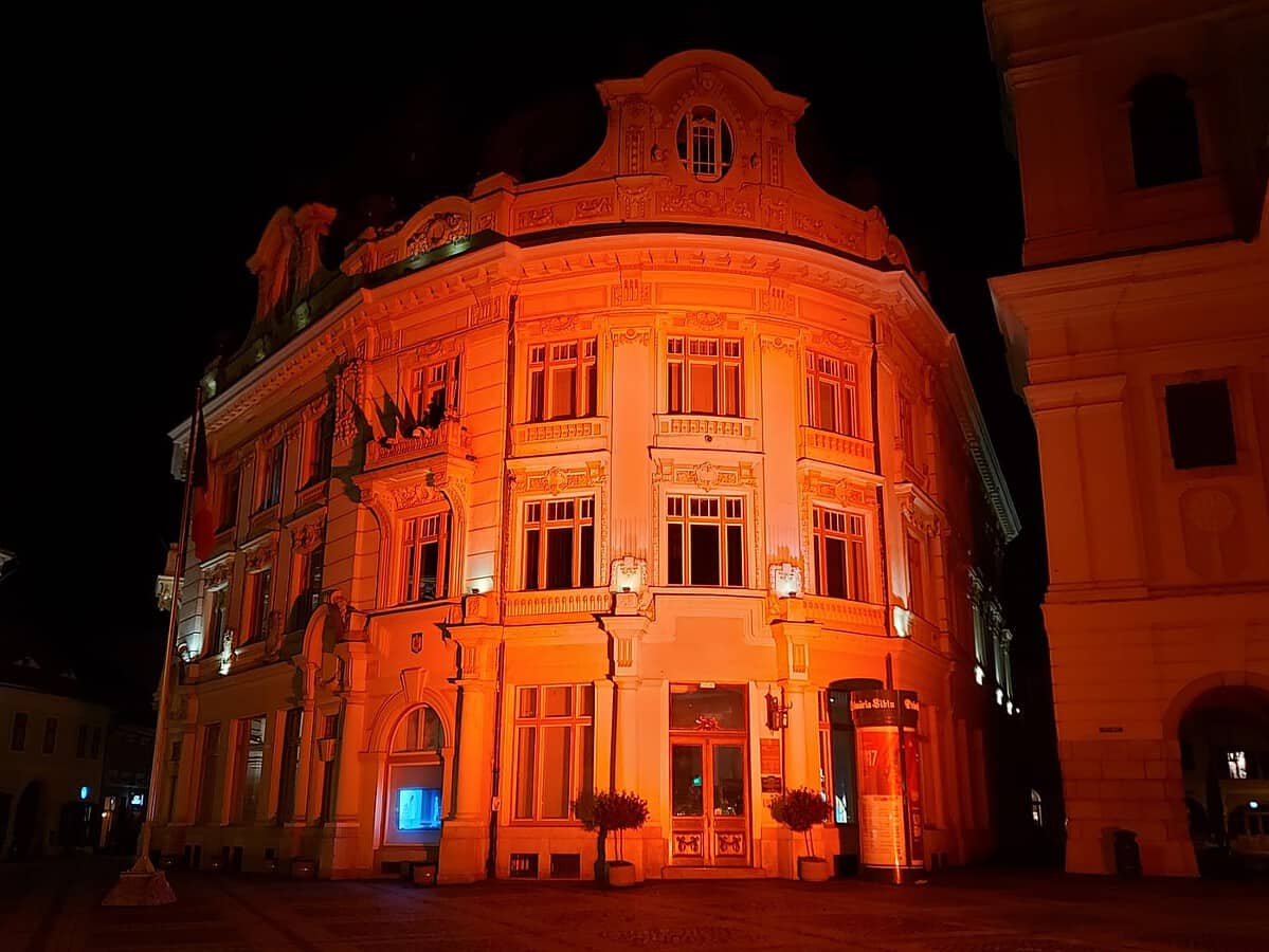 două clădiri din sibiu, iluminate în roșu pentru a marca ziua 112